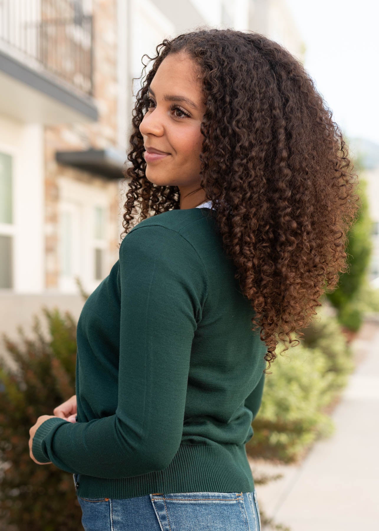 Modest side view of the pine green cardigan