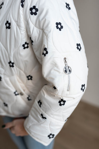 Zipper pocket on the sleeve of the ivory flower pruffer jacket