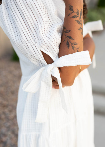 Close up of the fabric and sleeve of the white gingham dress