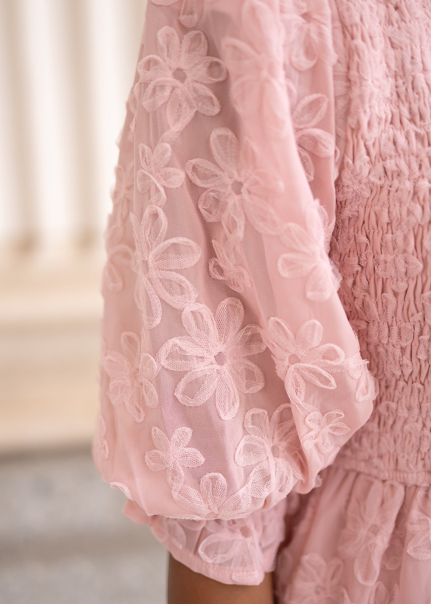 Close up of the sleeve and fabric on the blush floral textured dress
