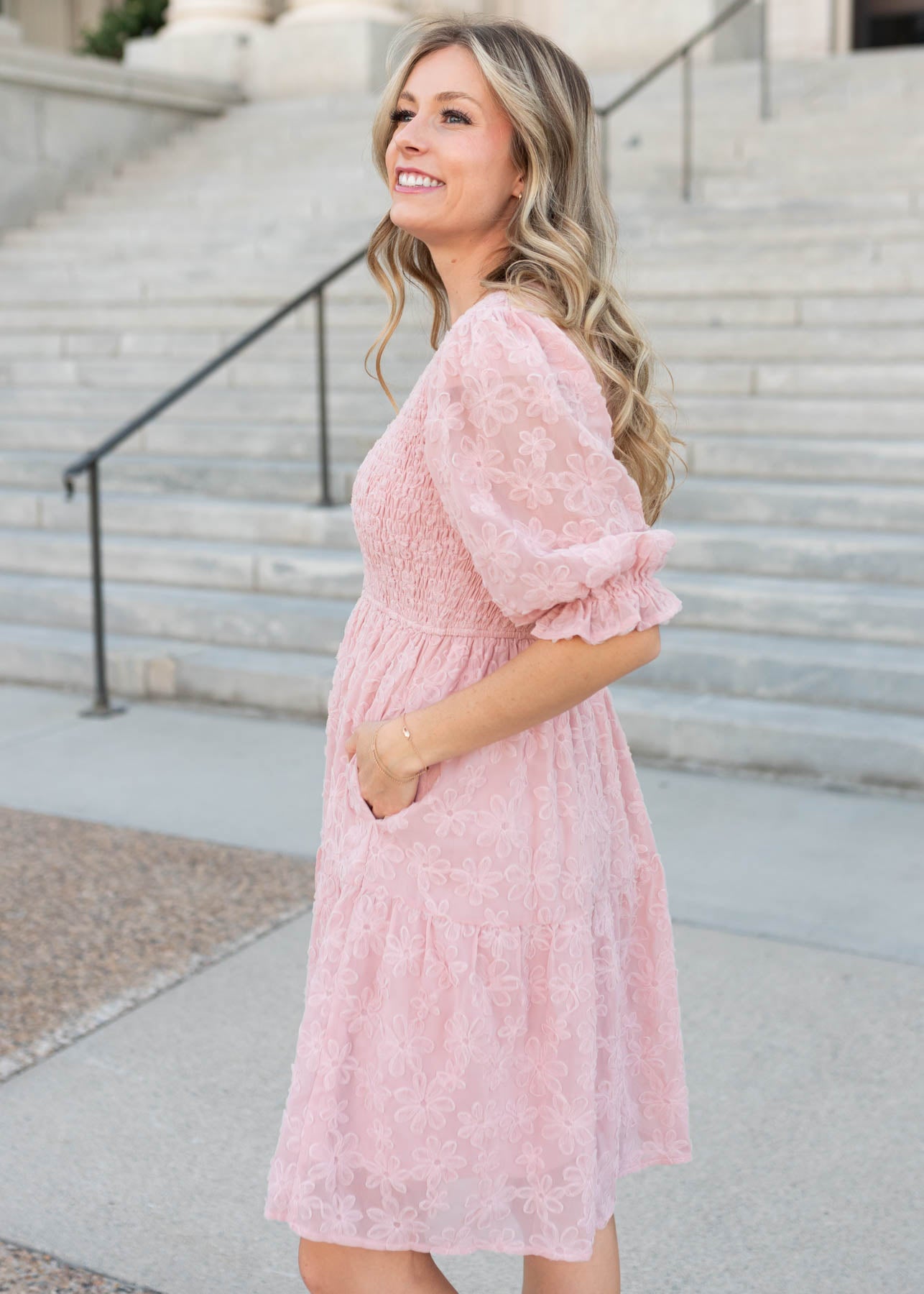Side view of the knee length Lena & Lou exclusive blush floral textured dress with pockets