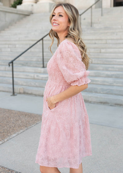 Side view of the knee length Lena & Lou exclusive blush floral textured dress with pockets
