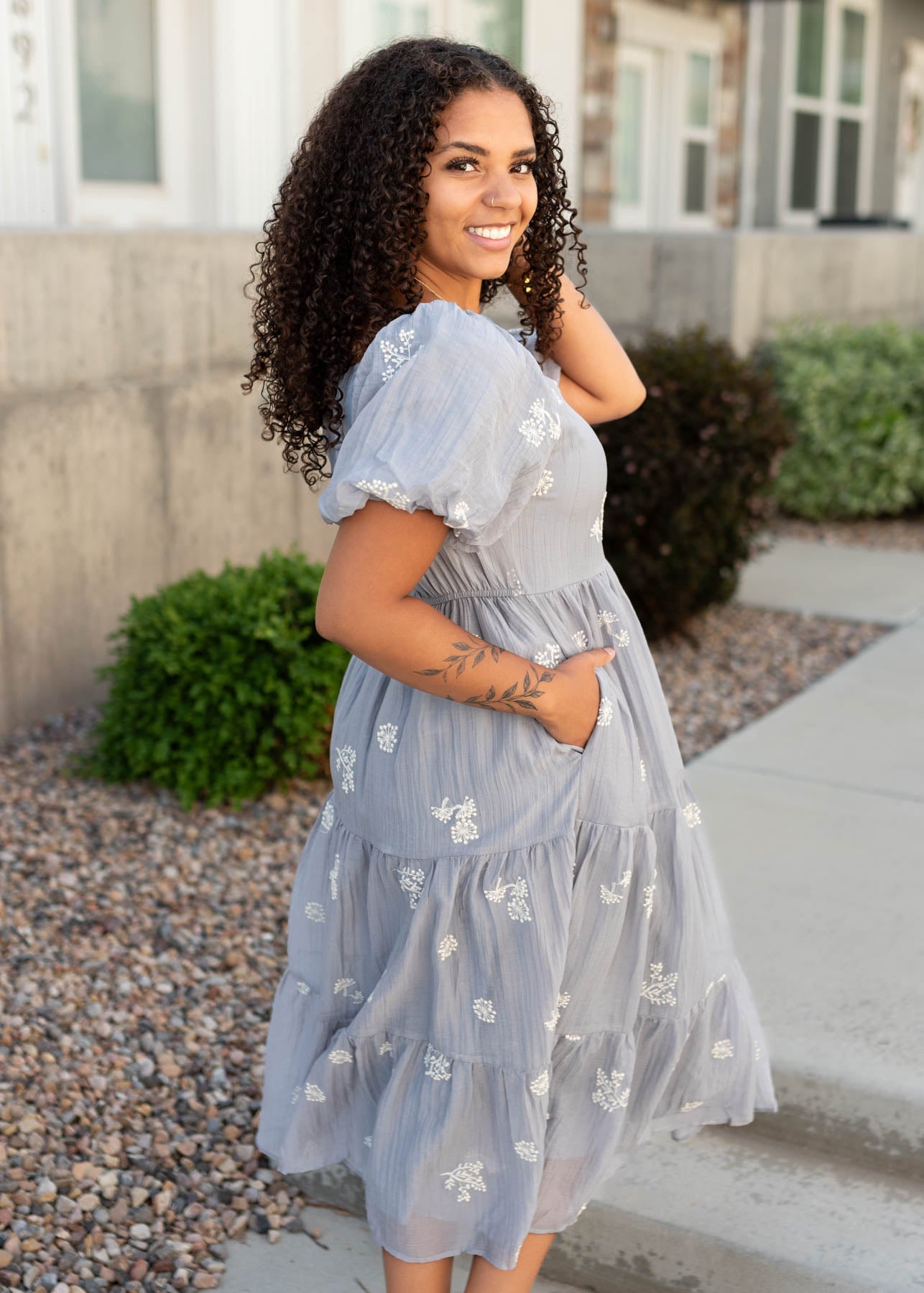 Side view of the dusty blue embroidered dress with pockets