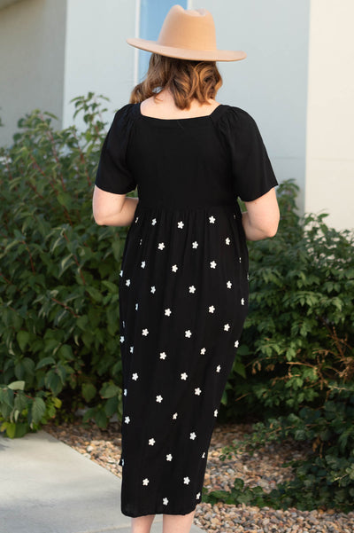 Back view of a black dress with flowers on the skirt