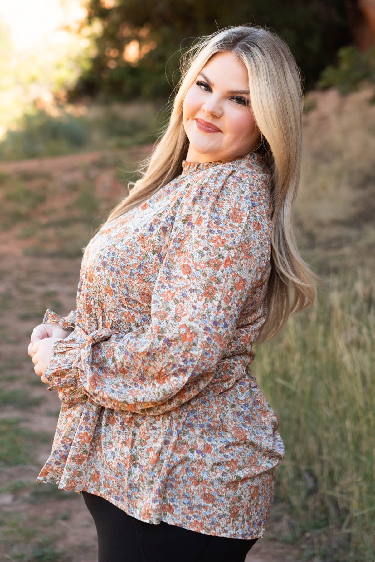 Side view of a plus size rust floral top