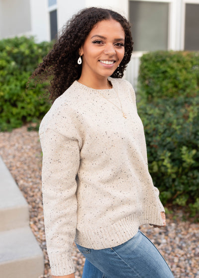 Side view of the speckled taupe knit sweater with dop sleeve and crew neck
