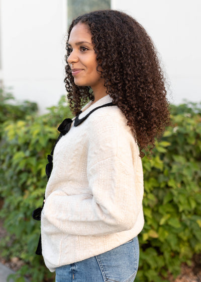 Side view of the cream bow cardigan