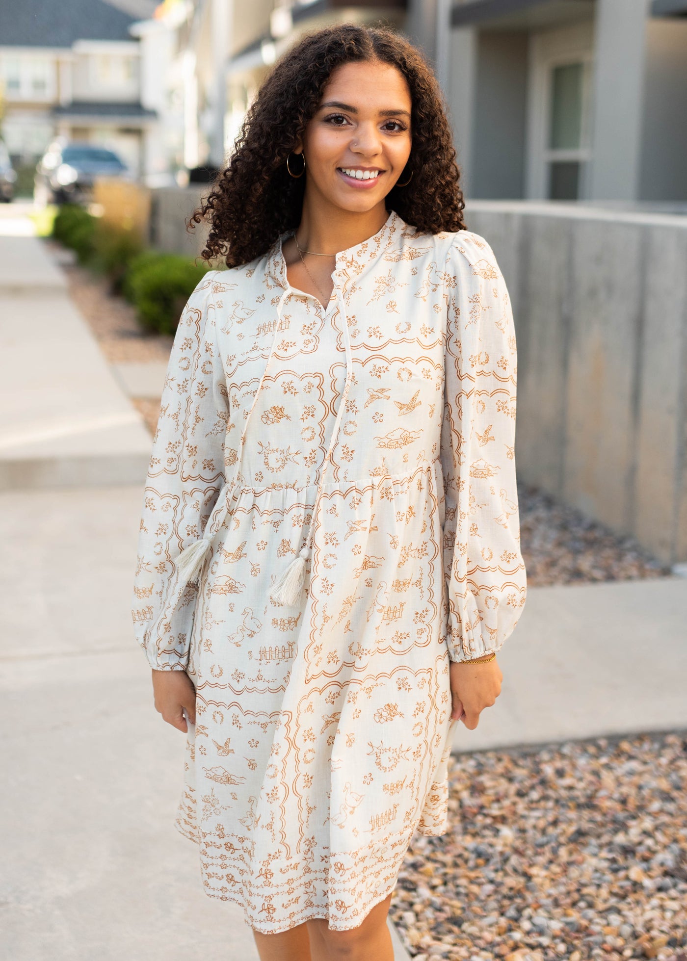 Modest cream patterned dress with a tie at the neck and long sleeves