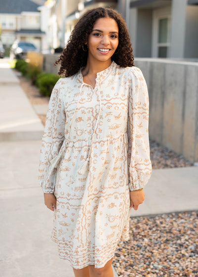 Modest cream patterned dress with a tie at the neck and long sleeves