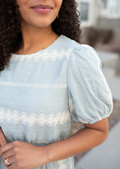 Close up of the fabric and sleeve on the light blue embroidered dress