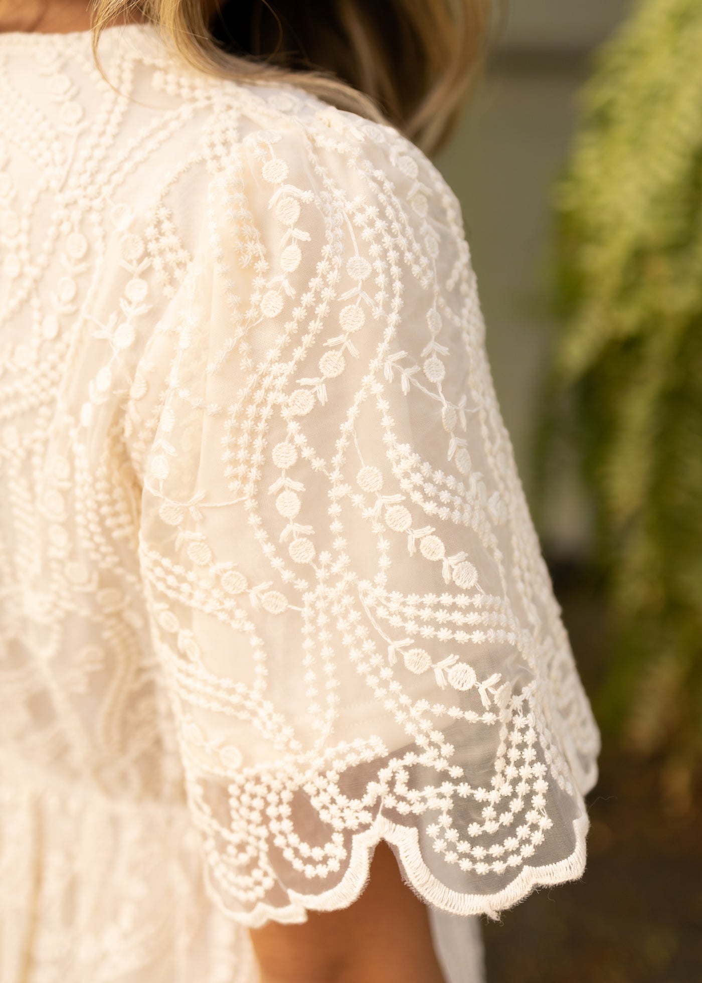 Sleeve of a plus size cream dress