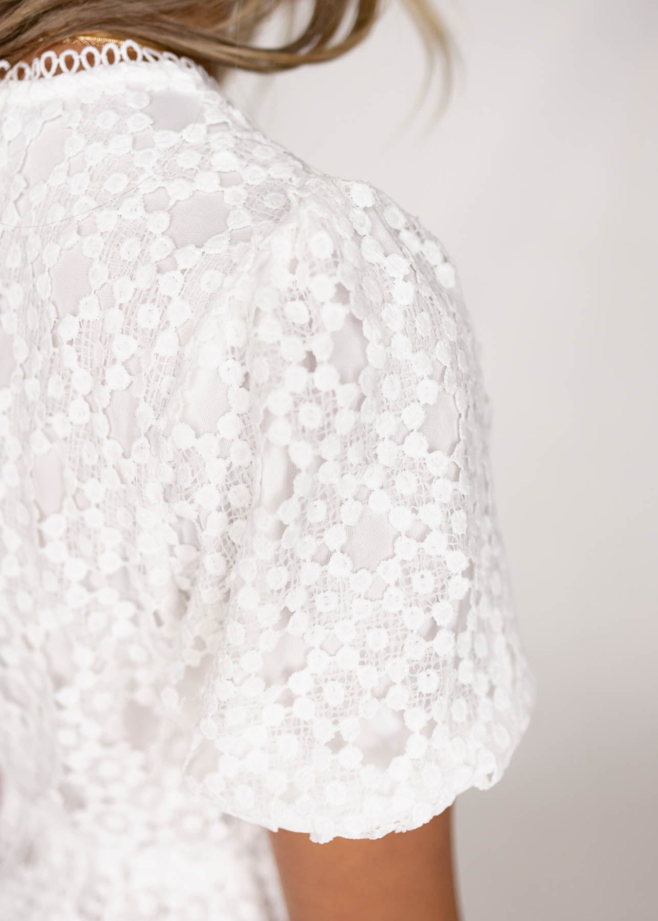 Sleeve of a white lace dress