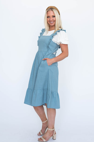 Blue jumper dress with pockets and ruffle on straps