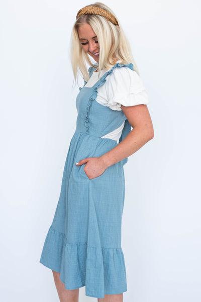 Side view of a jumper dress with pockets