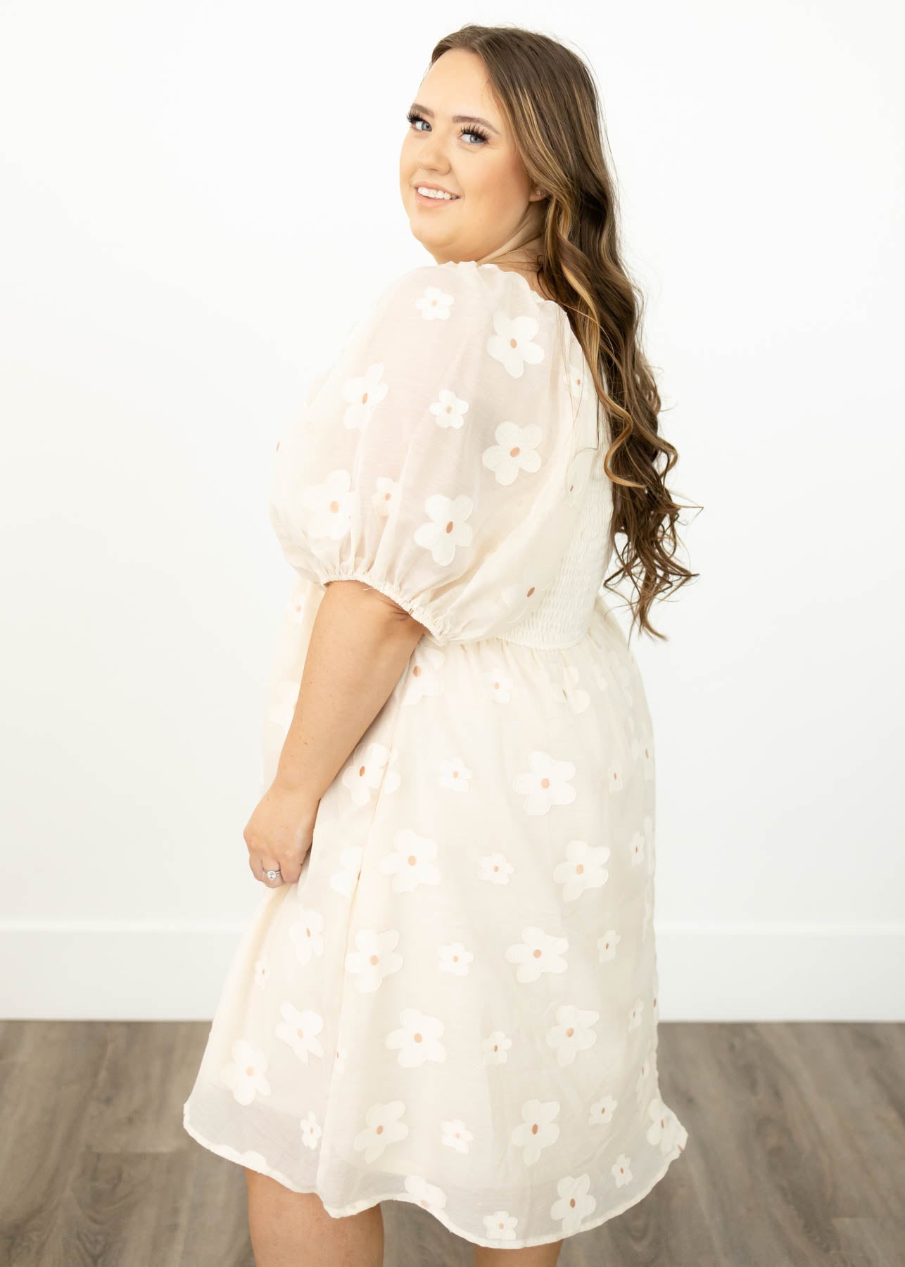 Side view of a plus size cream floral dress