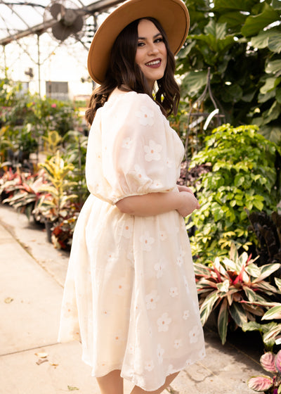 Side view of a plus size cream floral dress
