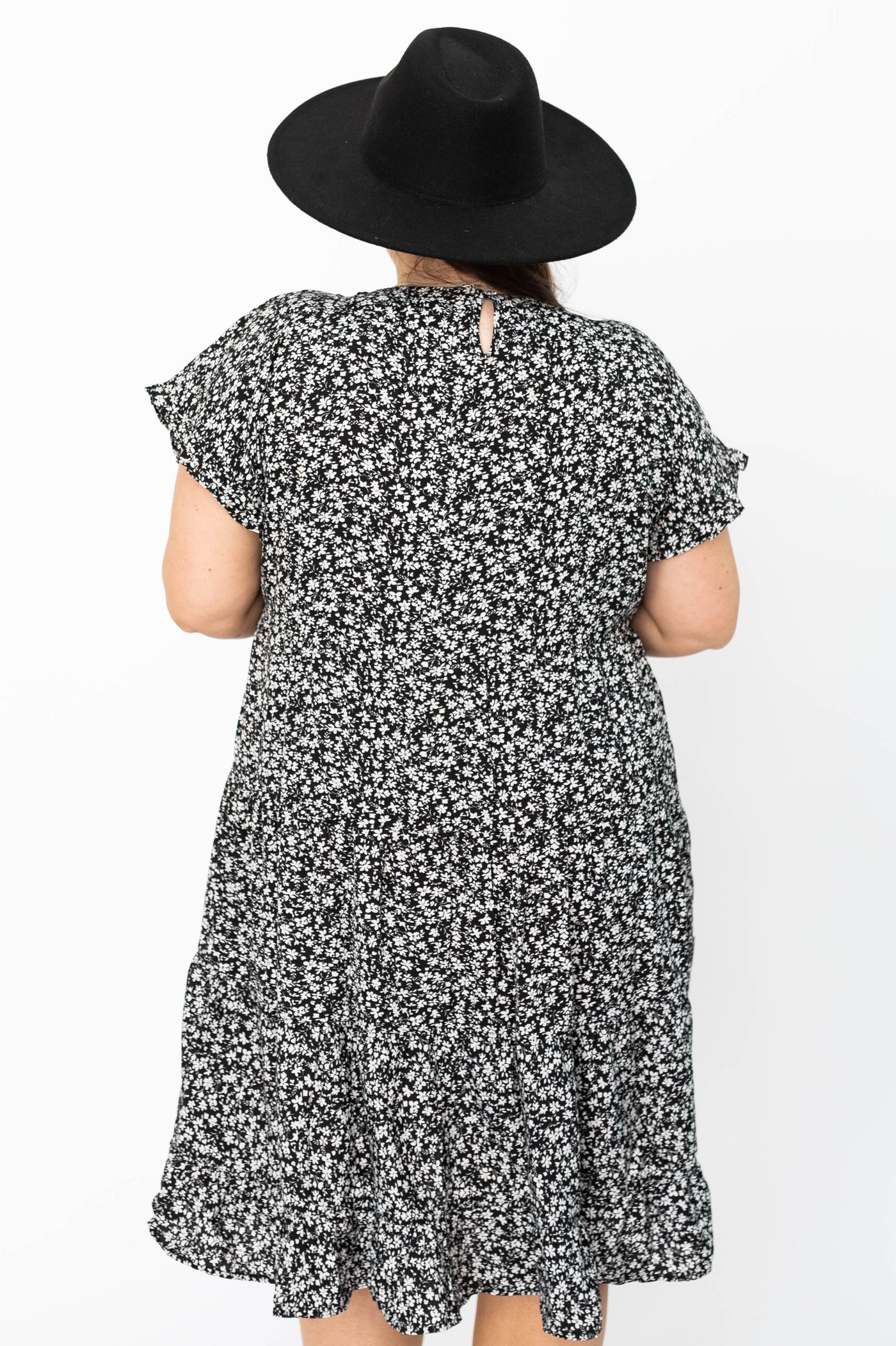 Back view of a plus size black floral dress