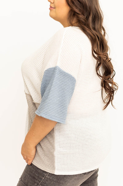 Plus size side view of a blue knit short sleeve top